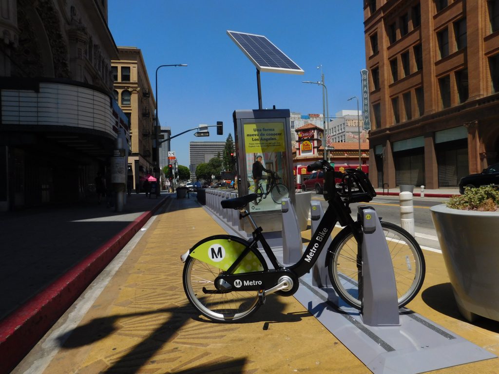 The loneliest Metro Bike awaits in front of the Grand Central Market, with the Million Dollar Theater and the Bradbury Building in the background